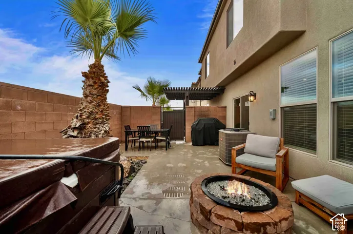 Private patio with a built-in fire pit, a hot tub, and a pergola