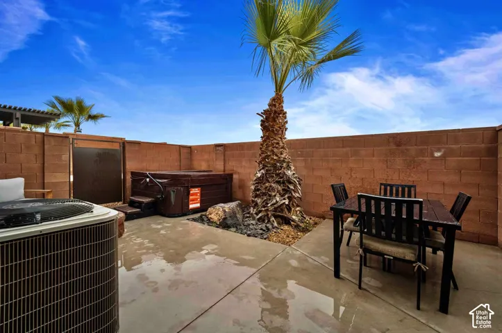 Private patio with concrete flooring, block wall fencing, and a built-in spa