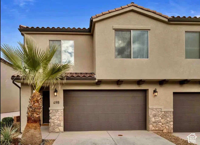Stucco exterior with stone accents, tile roof, and attached garages