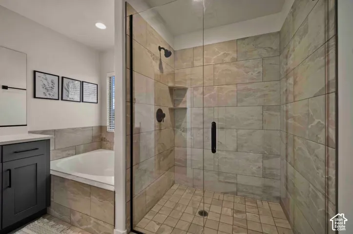 Glass-enclosed shower with stone-look tile, built-in shower niche, and matte black fixtures