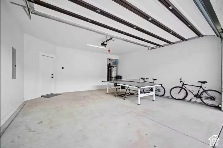 Spacious garage with light gray concrete flooring, white painted walls, and an overhead garage door mechanism