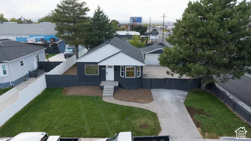 Single-story residence featuring a dark-toned exterior with white trim, a gabled roof, and a prominent front entrance with a white door