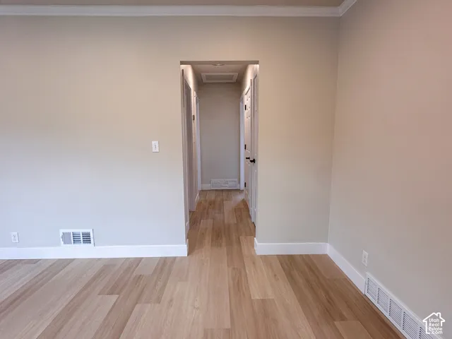 Interior space featuring wood-finish flooring, neutral wall paint, and white trim molding throughout