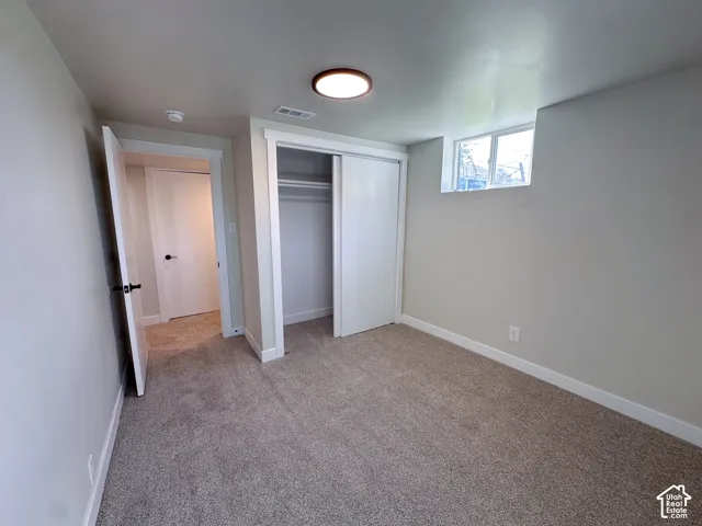 Neutral-toned wall paint with a window, complete with a built-in closet and a flush mount ceiling light
