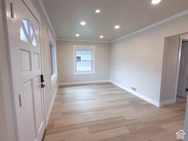 Wood-finish flooring throughout, recessed lighting, crown molding, and white trim accents
