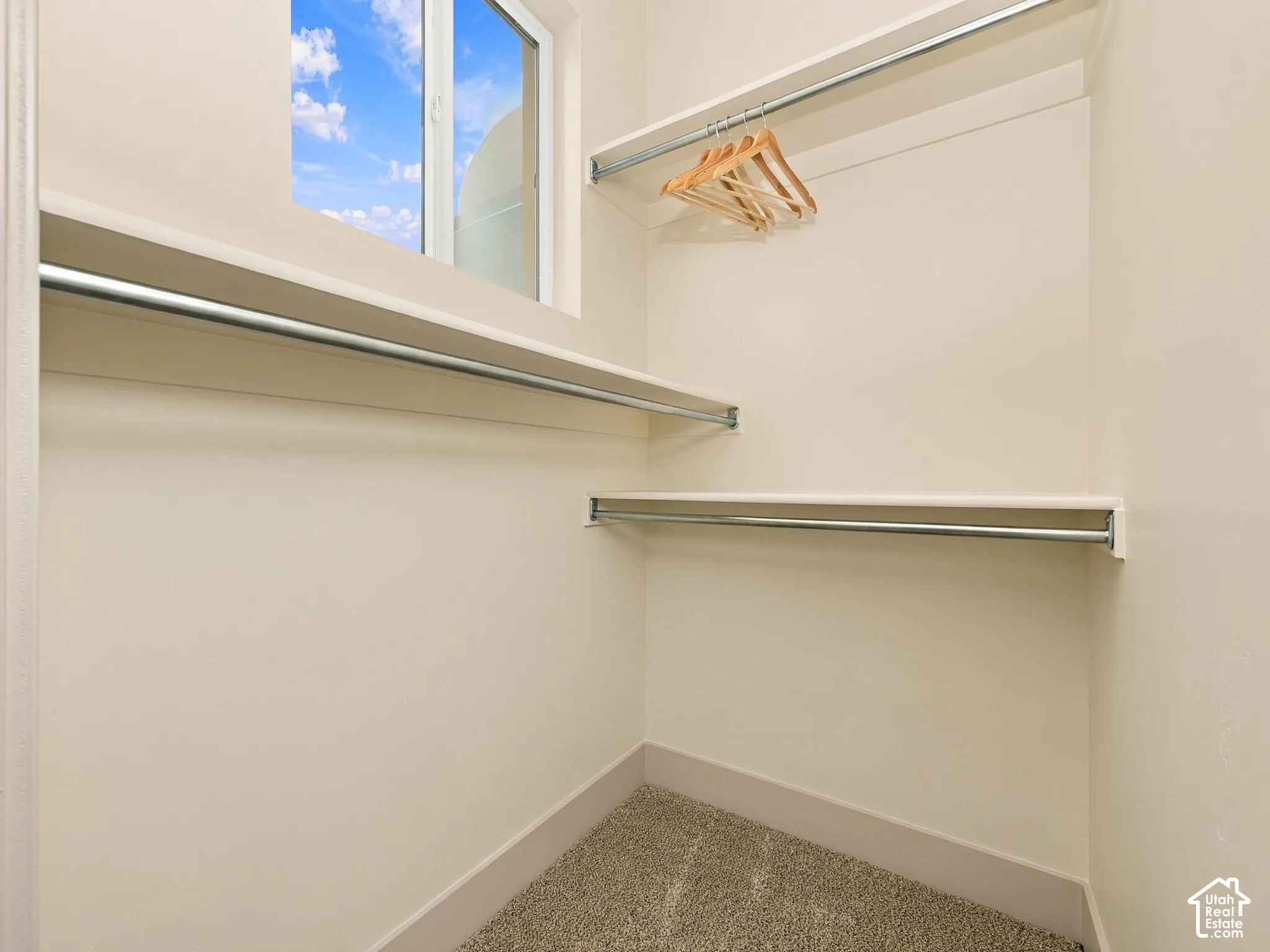 Built-in shelving, chrome hanging rods, and a window for natural light