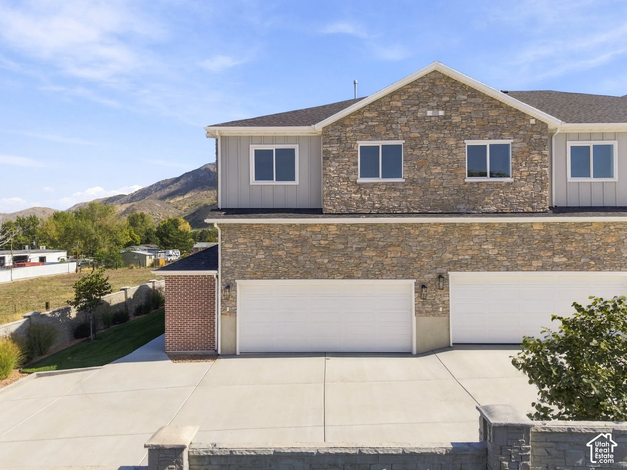 Stone veneer and vertical siding exterior with multiple windows