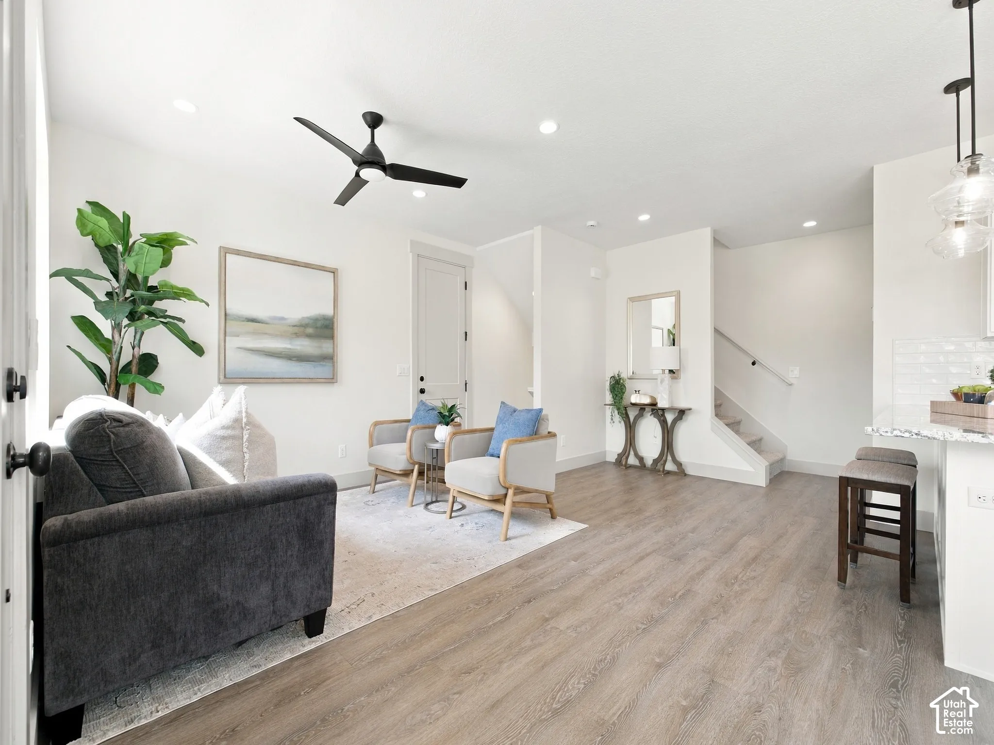 Open-concept living space featuring wood-finish flooring, recessed lighting, and a ceiling fan