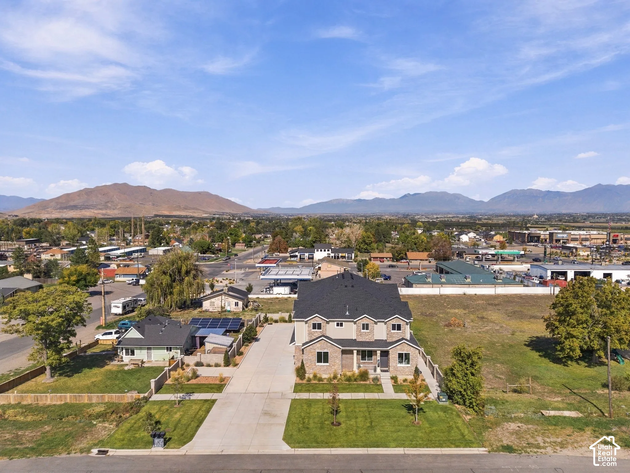 Two-story property with a multi-gabled roof, stone and siding exterior, and a paved driveway