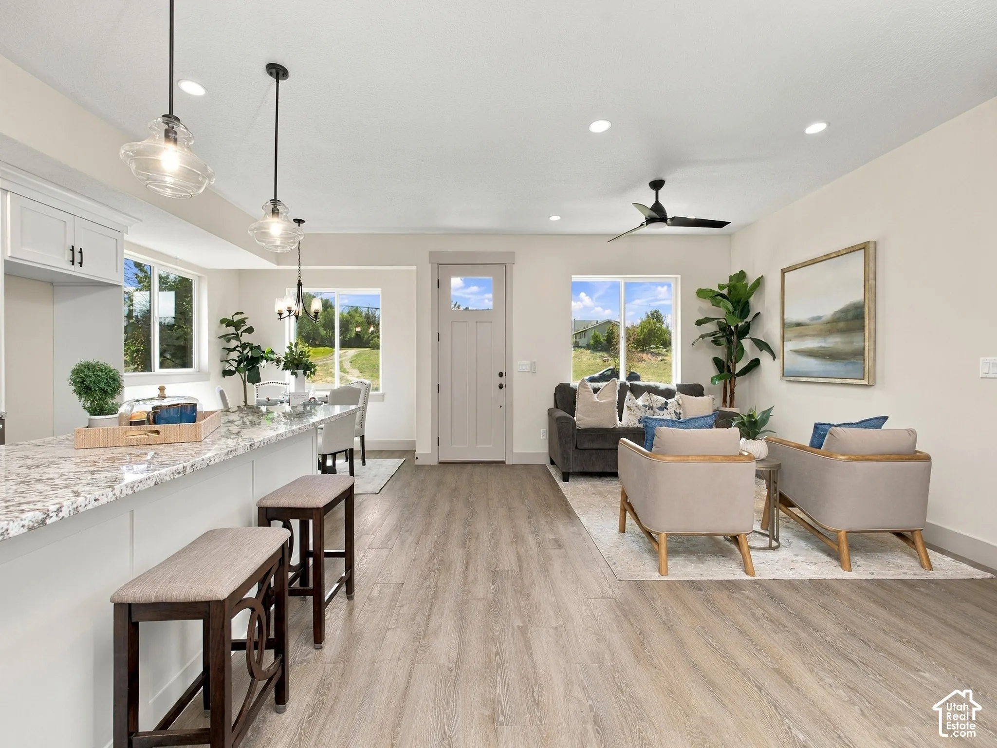 Granite-style countertop, wood-finish flooring, recessed lighting, ceiling fan, and multiple windows