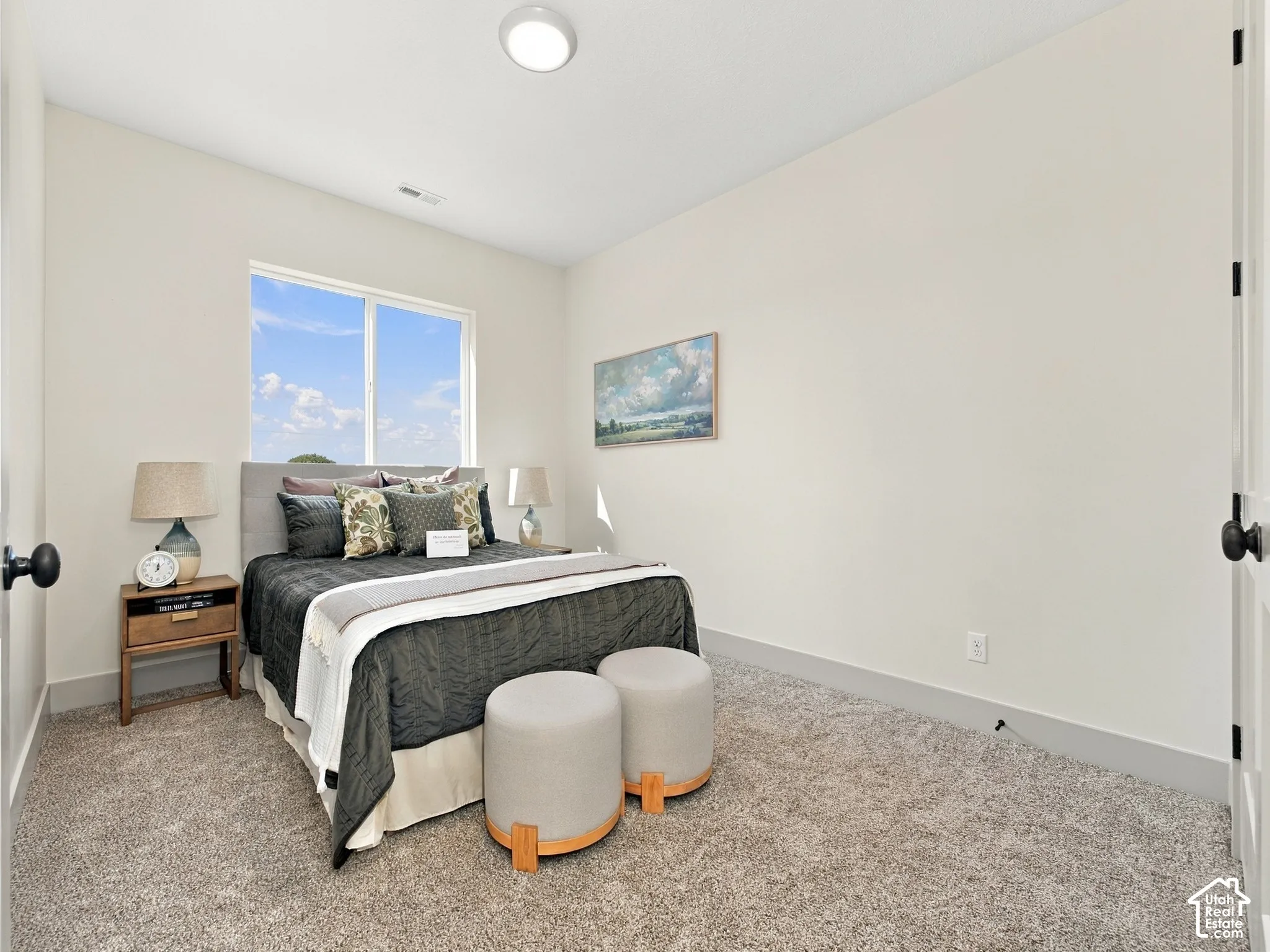 Recessed ceiling lighting, large window with natural light, neutral wall colors, textured carpeting, and white trim