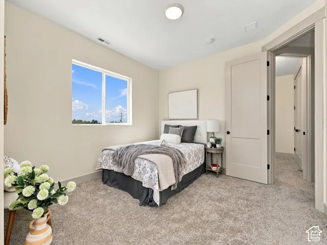 Plush carpet flooring, neutral painted walls, white trim, recessed lighting, and a white framed window