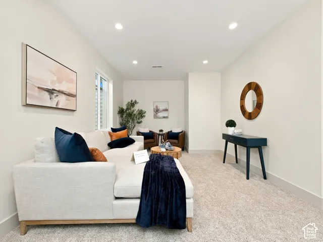 Recessed lighting, light-toned walls, and neutral carpeting