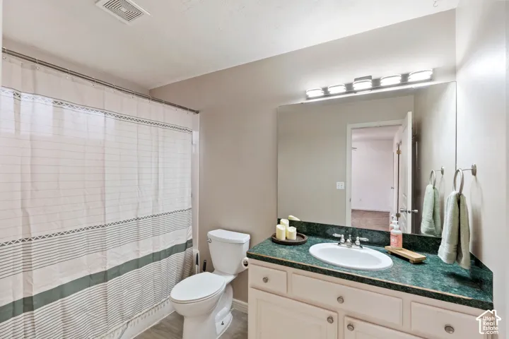 Master Bathroom featuring a vanity with a dark green countertop, integrated sink, and white cabinetry