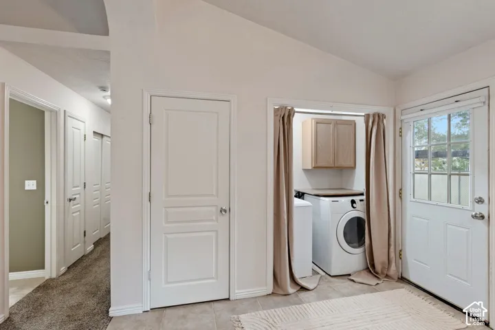 Tile flooring, laundry area with built-in cabinetry, and white paneled doors