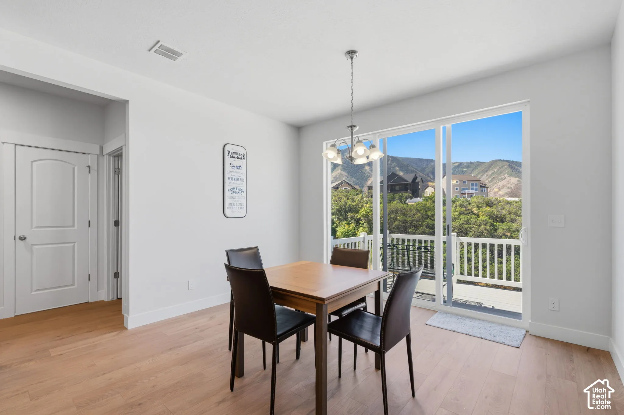 White walls, and a sliding glass door opening to a deck with white railings.