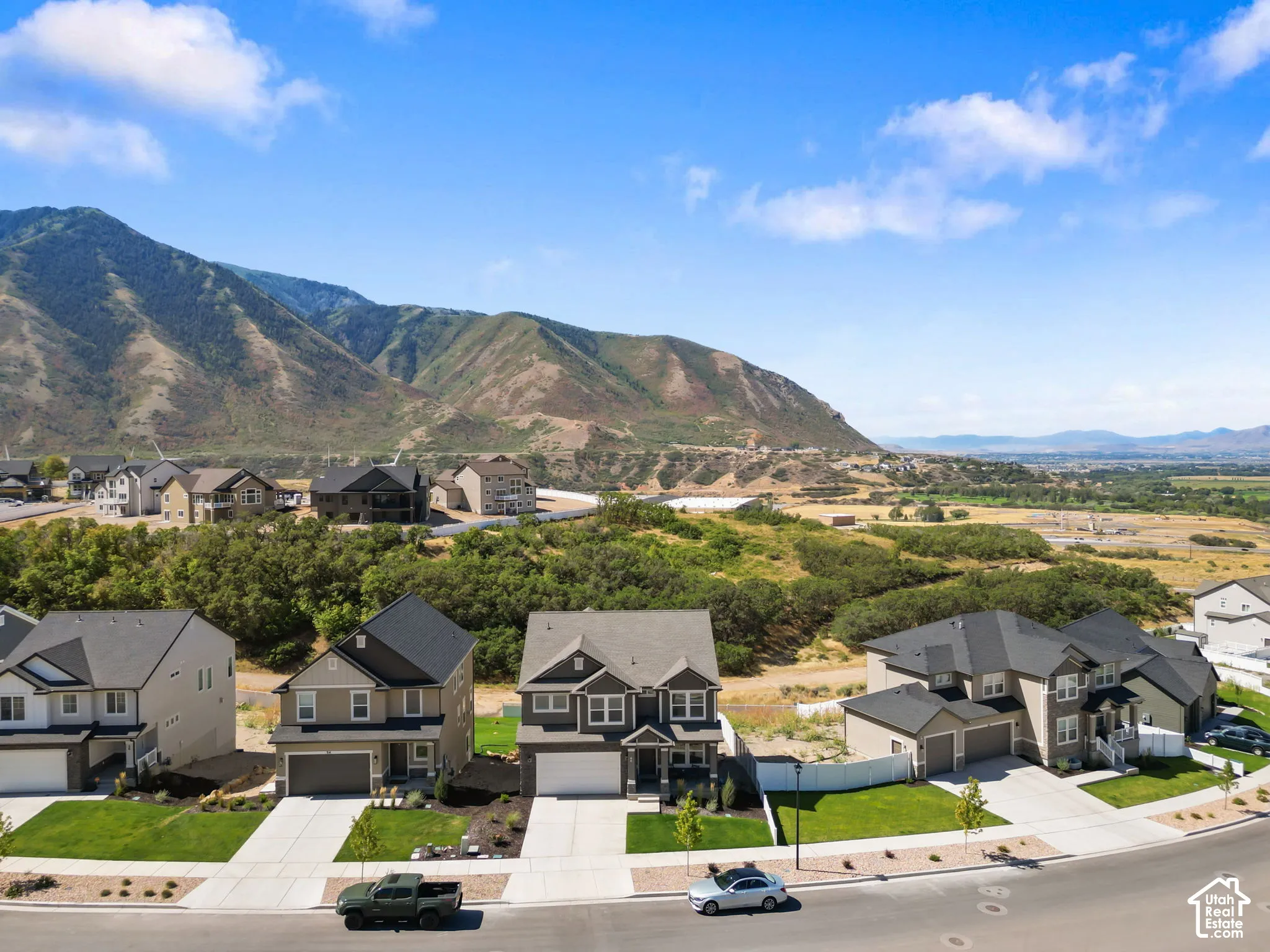 Aerial perspective featuring mountain scenery, residential street, and surrounding terrain.