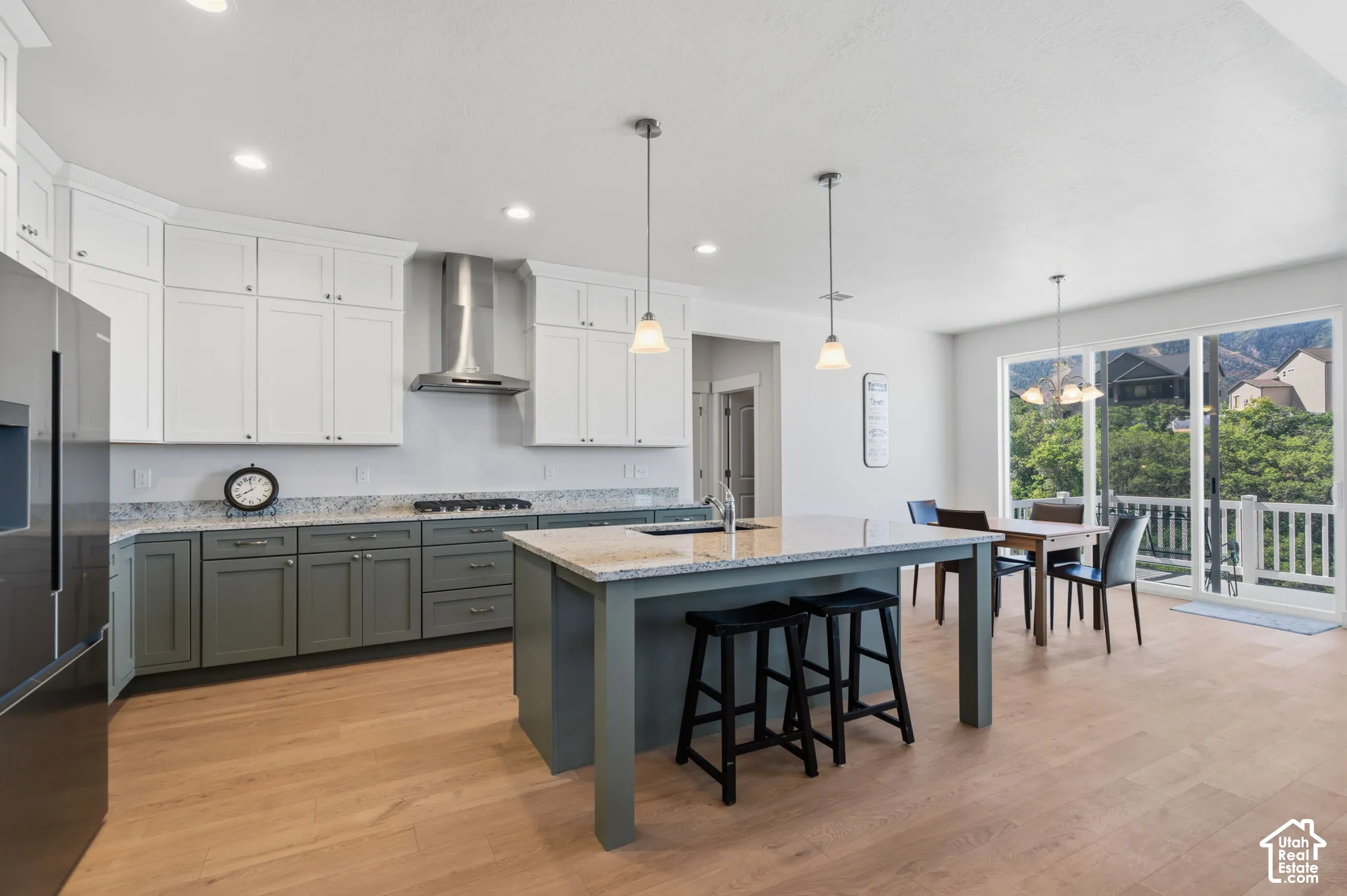 Chef's kitchen featuring white cabinetry, stainless steel appliances, a gas cooktop with range hood.
