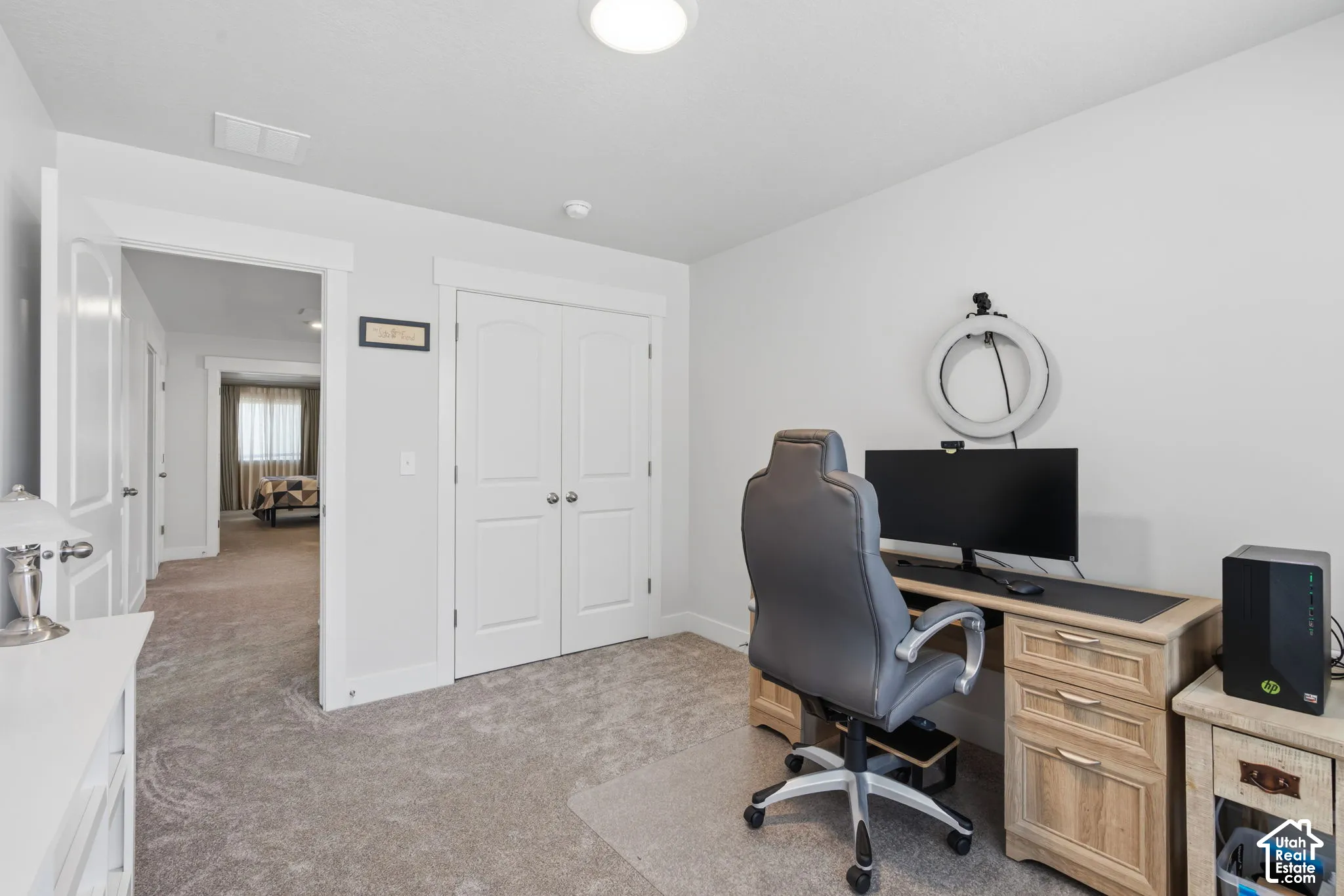 Bedroom or dedicated home office featuring carpet, recessed ceiling lighting, white shaker-style closet doors with hardware, and direct access to adjoining spaces.