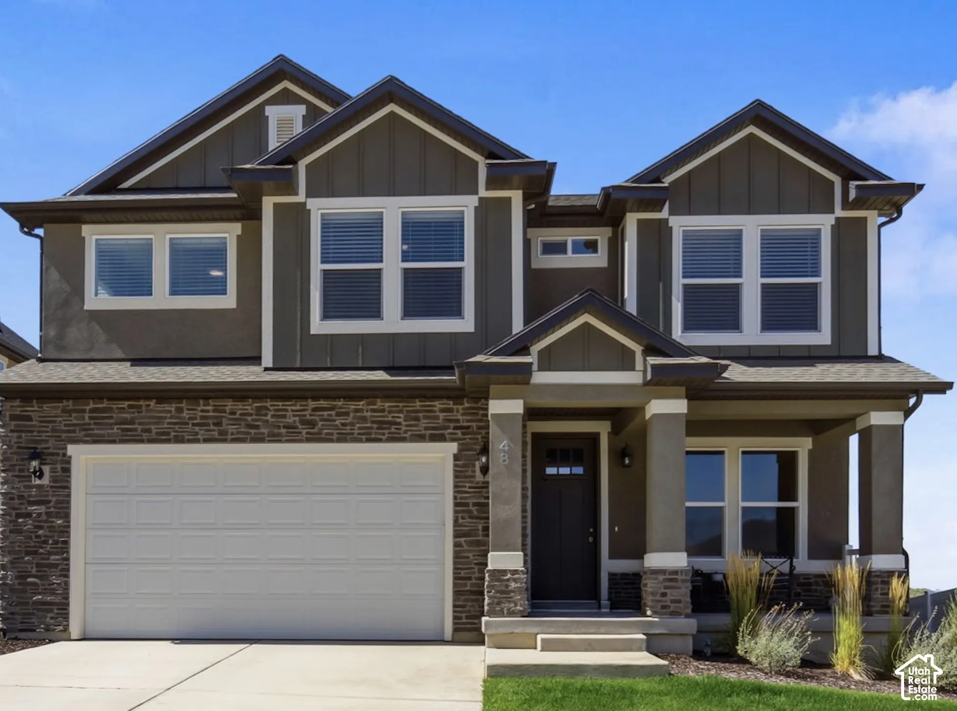 Contemporary two-story residence featuring hardie board trim with stucco and stone exterior.
