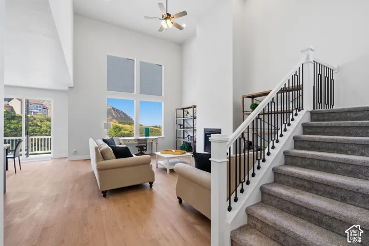 Double-height ceilings, large multi-pane windows, built-in fireplace, and a prominent staircase.