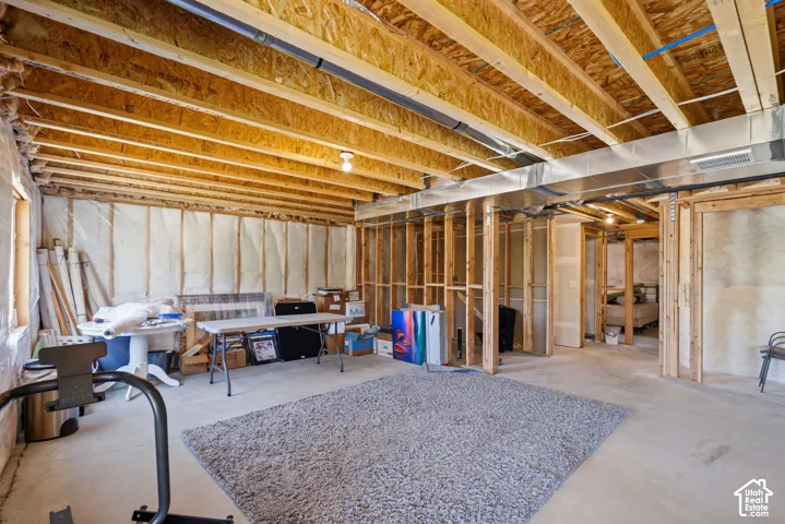 Unfinished basement with exposed ceiling joists and structural framing.