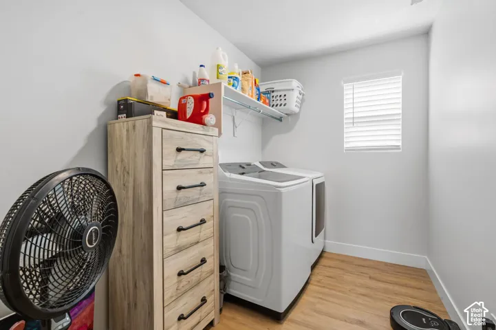 Dedicated laundry room featuring, wall-mounted shelving and a bright window with louvered blinds for natural light and ventilation.