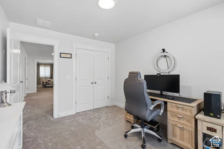 Bedroom or dedicated home office featuring carpet, recessed ceiling lighting, white shaker-style closet doors with hardware, and direct access to adjoining spaces.