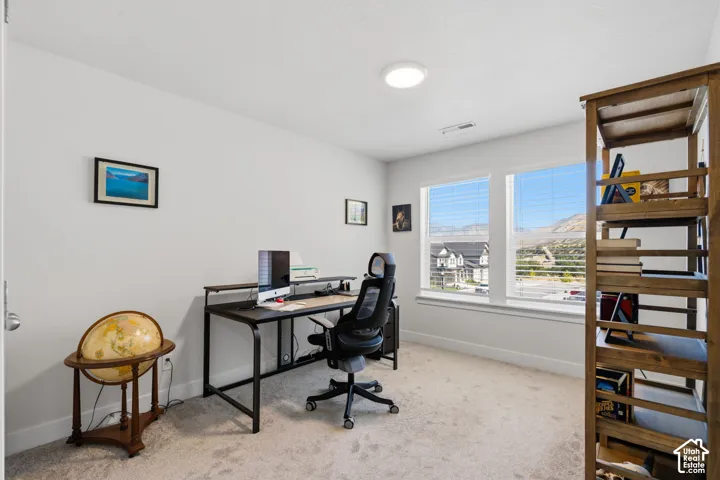 Neutral wall color, carpeted flooring, and two windows with horizontal blinds.