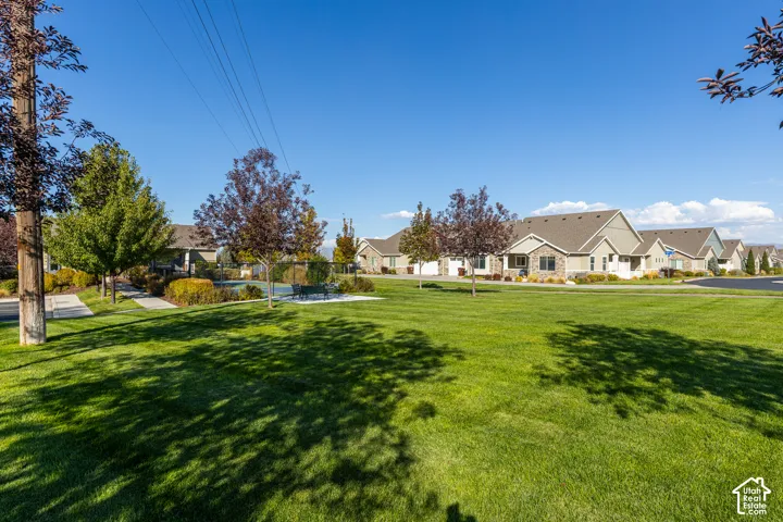 Expansive green space featuring a manicured lawn and mature trees