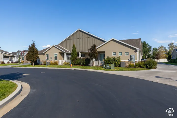 Building exterior with stucco siding, pitched roof, and landscaping