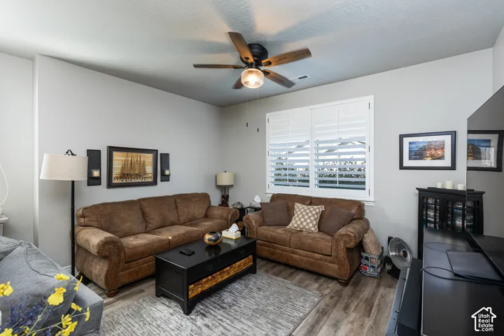 Recessed lighting, ceiling fan, hard-surface flooring, white plantation shutters, and a mounted flat-screen television