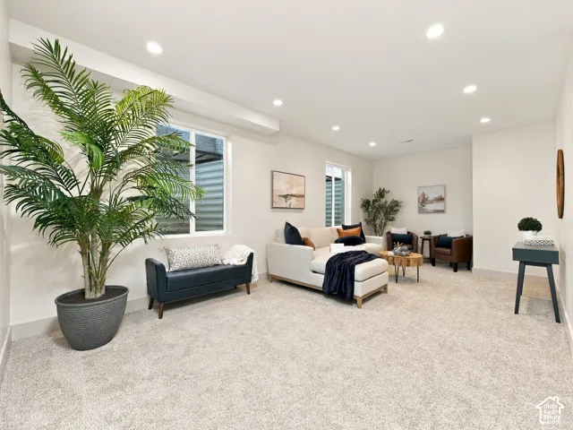 Recessed lighting, light-toned carpeting, and multiple windows
