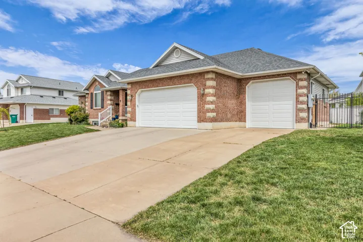 Brick exterior with decorative stone accents, dual garage doors, and a concrete driveway