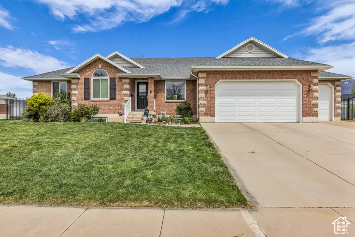 Brick exterior with decorative stone accents, arched window, and a two-car garage