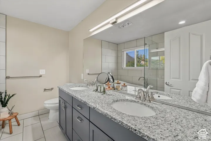 Double vanity with undermount sinks, speckled countertop, and brushed nickel fixtures