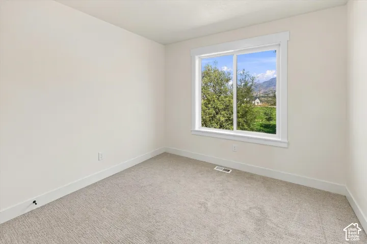 Neutral wall color, carpeted flooring, white trim, window, and mountain scenery