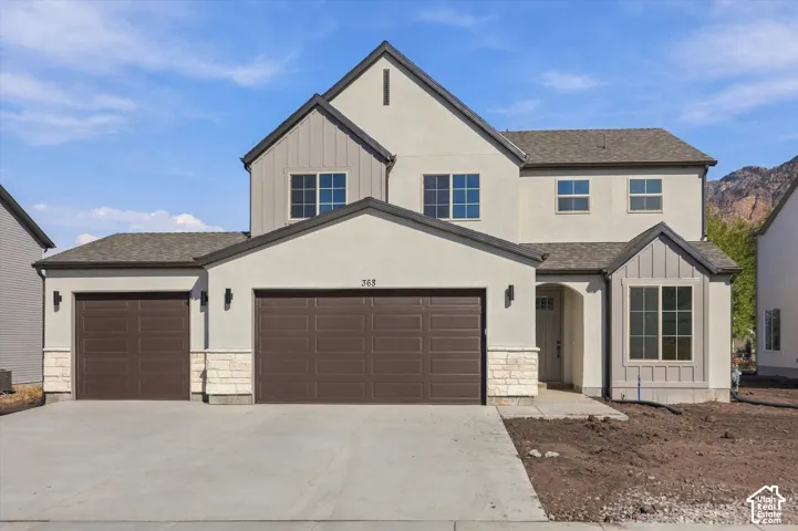 Contemporary stucco exterior with a multi-gabled roofline and board-and-batten accents