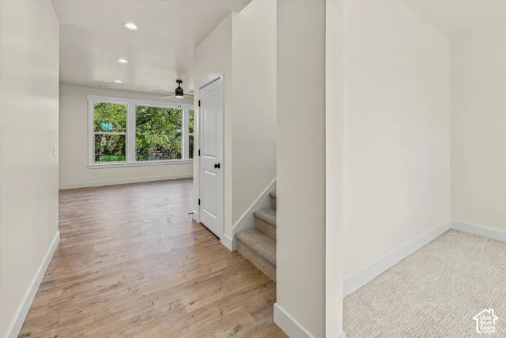 Wood-finish flooring, recessed lighting, white trim, and a ceiling fan