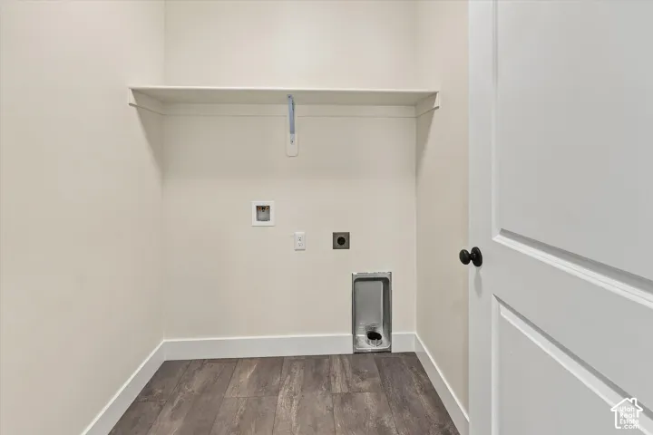 Laundry area featuring wood-finish flooring, a utility shelf, and white trim