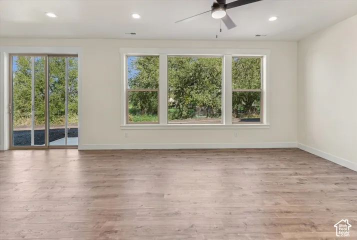 Wood-finish flooring throughout, with a ceiling fan and recessed lighting
