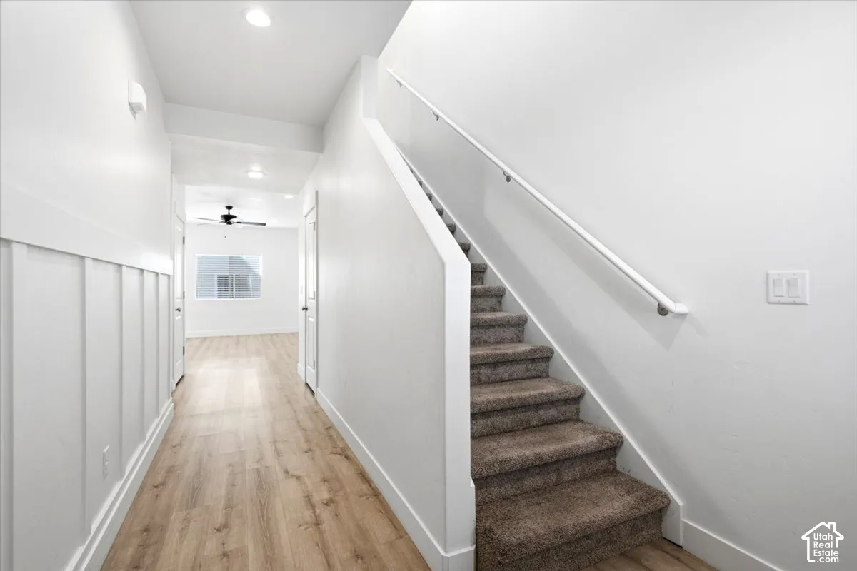 Staircase with carpeted treads and a white handrail