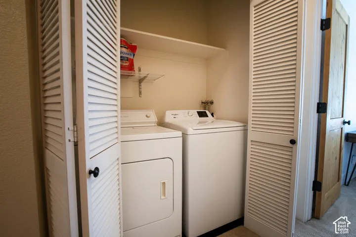 Dedicated laundry room featuring side-by-side washer and dryer units, louvered bifold closet doors, built-in shelving, and a fire extinguisher for safety preparedness