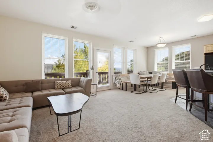 Spacious open-concept living area with multiple large windows, recessed lighting, and a ceiling fan