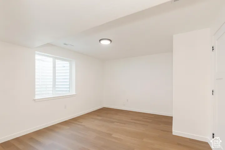 Recessed window, wood-finish flooring, white walls, and a ceiling-mounted light fixture