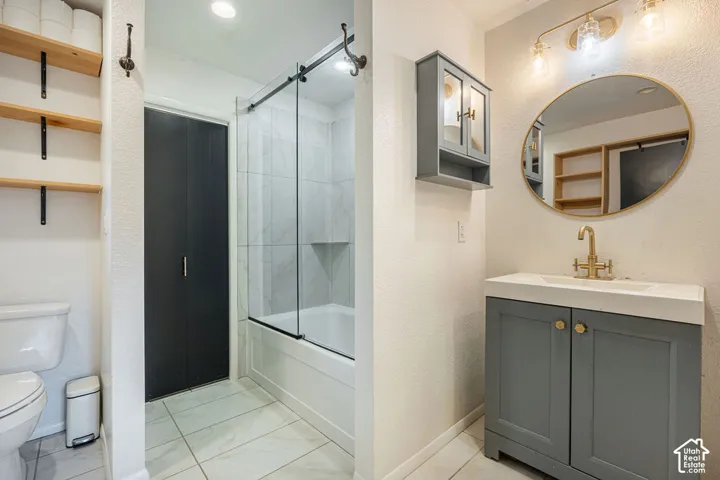 Modern vanity with gray cabinetry and brass-finish hardware