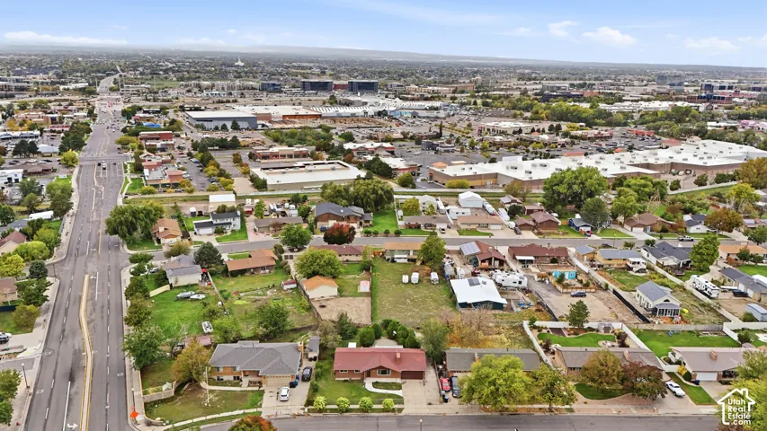 Aerial perspective of the property featuring a generous lot size, mature trees, and street-level access