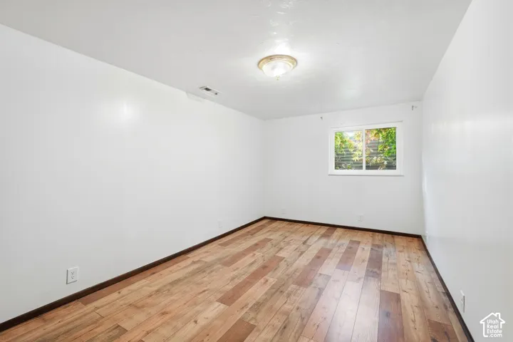 Interior space featuring wood-finish flooring, a single window, and a ceiling-mounted light fixture