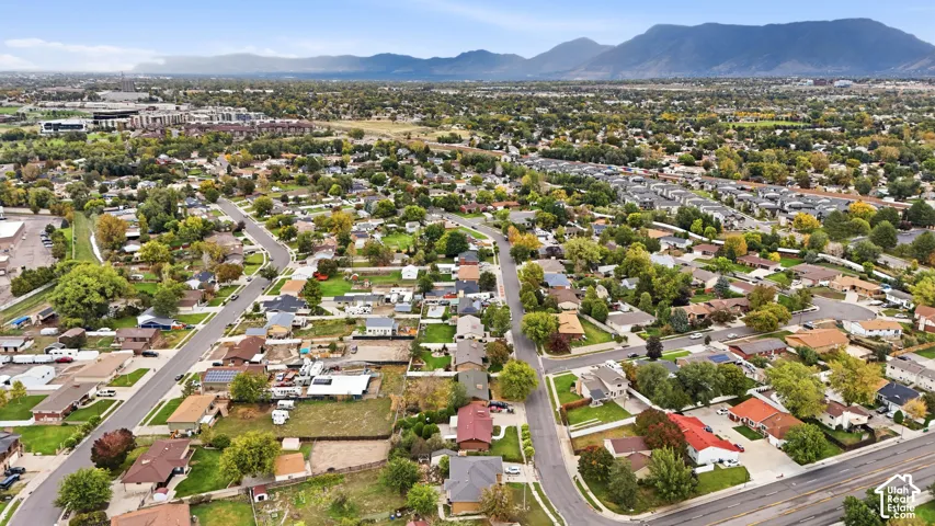 Aerial perspective featuring expansive residential lots, mature trees, and a mountain backdrop