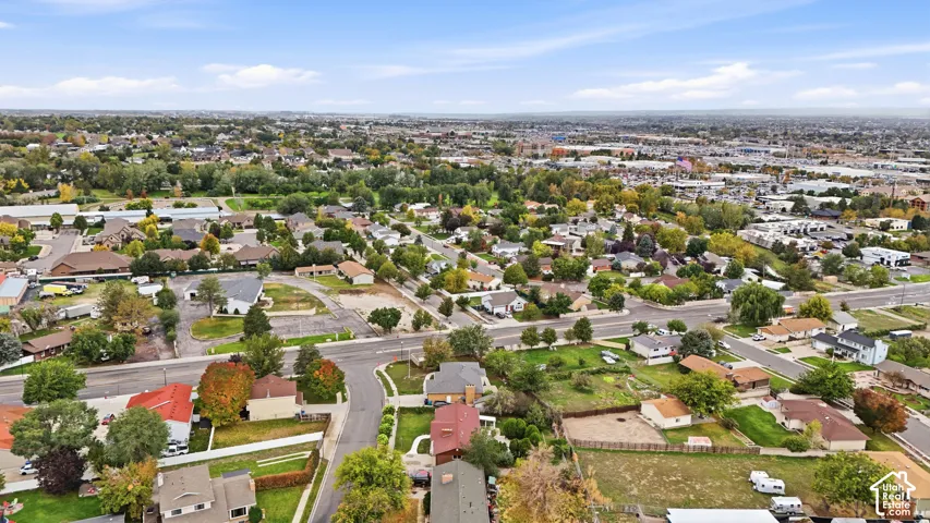 Aerial perspective of a neighborhood setting featuring paved streets, mature trees, and established residential lots